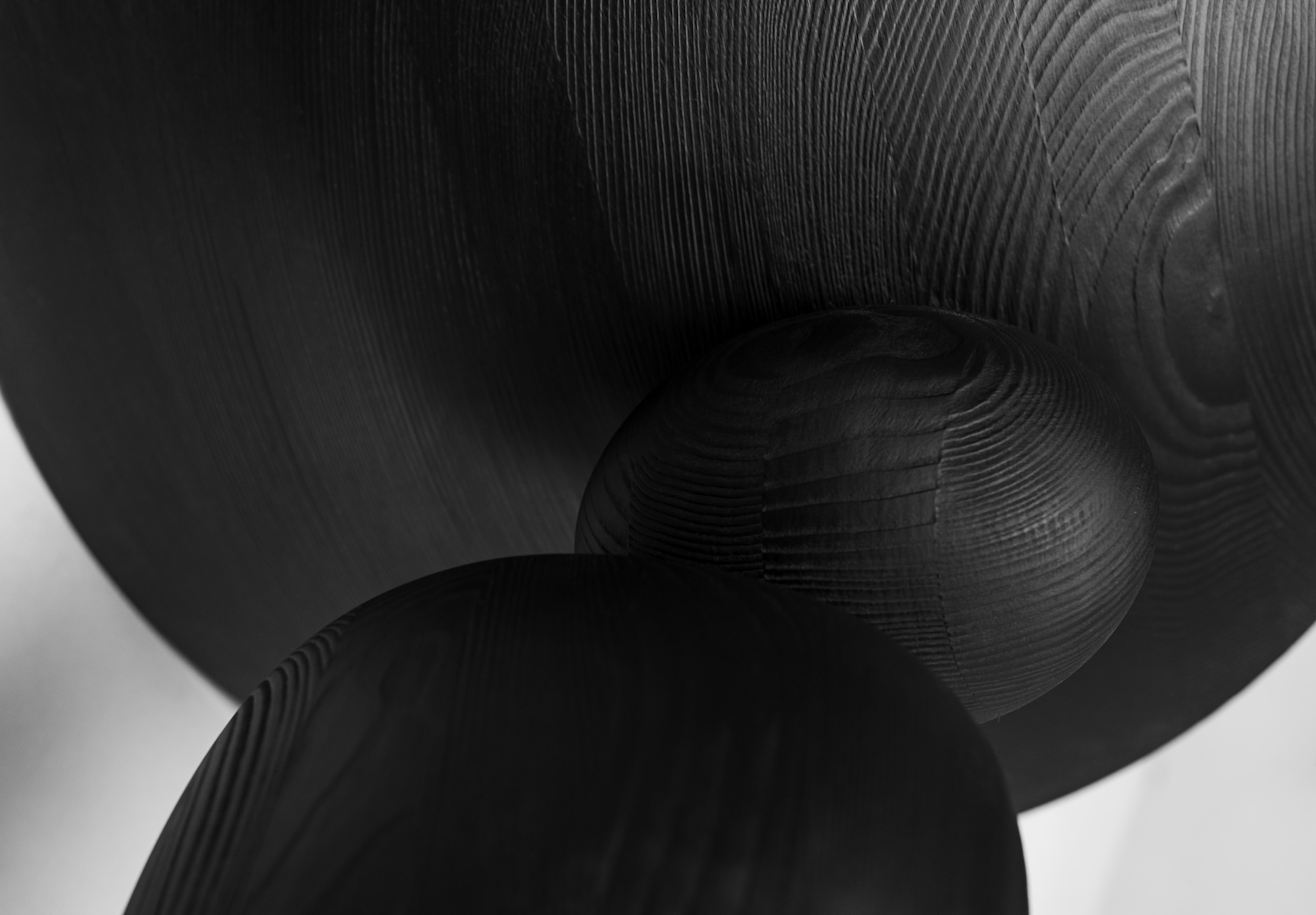 Detail der balancierenden Holzvolumen des Beistelltischs LIGNA in Schwarz