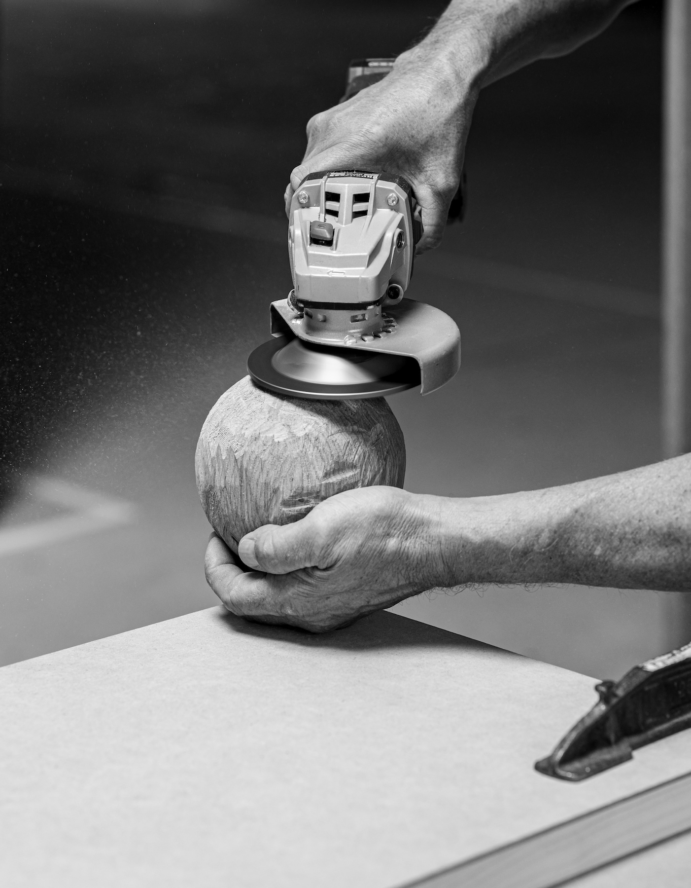 Handwerker schleift ein Holzvolumen für den Beistelltisch LIGNA in der Manufaktur Röthlisberger
